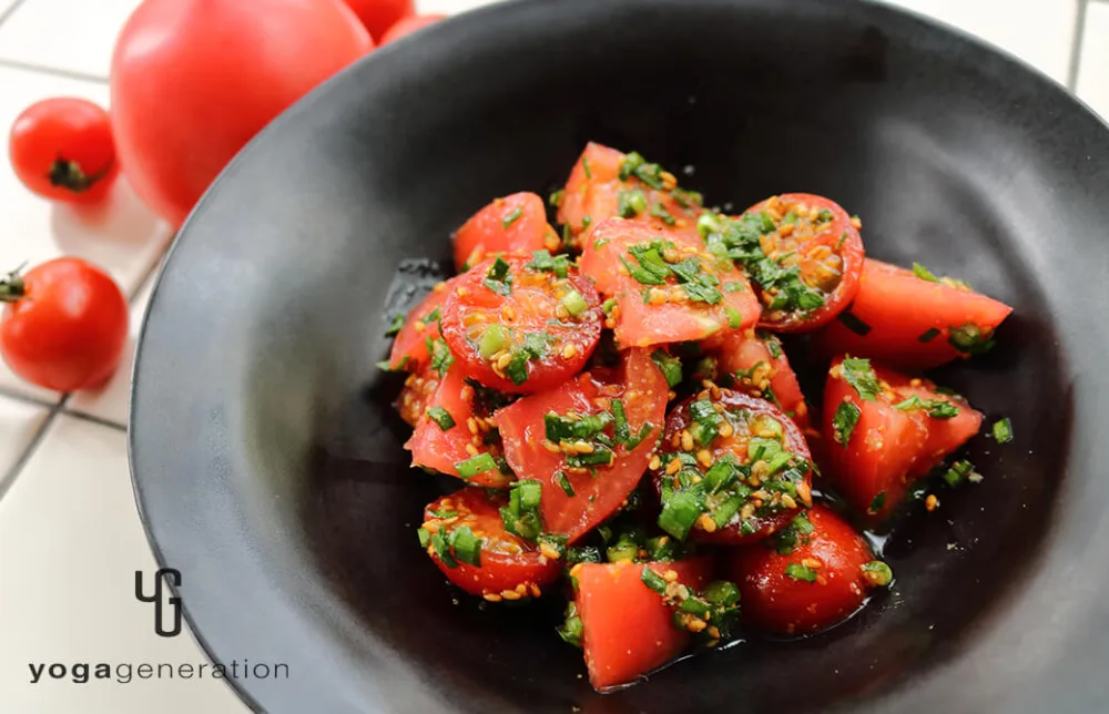 光沢のあるお皿に盛り付けたゴマ香るトマトとニラのナンプラーマリネ