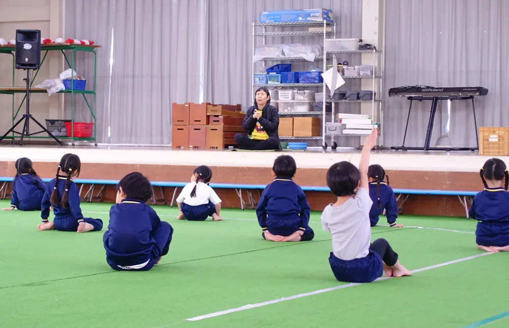 保育園のキッズヨガで手を挙げている子ども